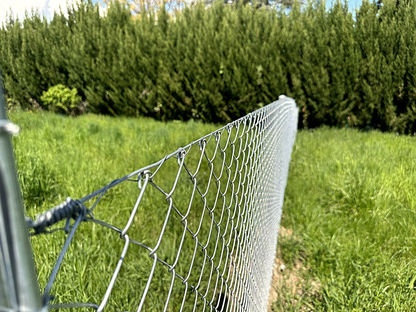 Finishing detail of a galvanised wire mesh fence, Concept Clôtures craftsmanship